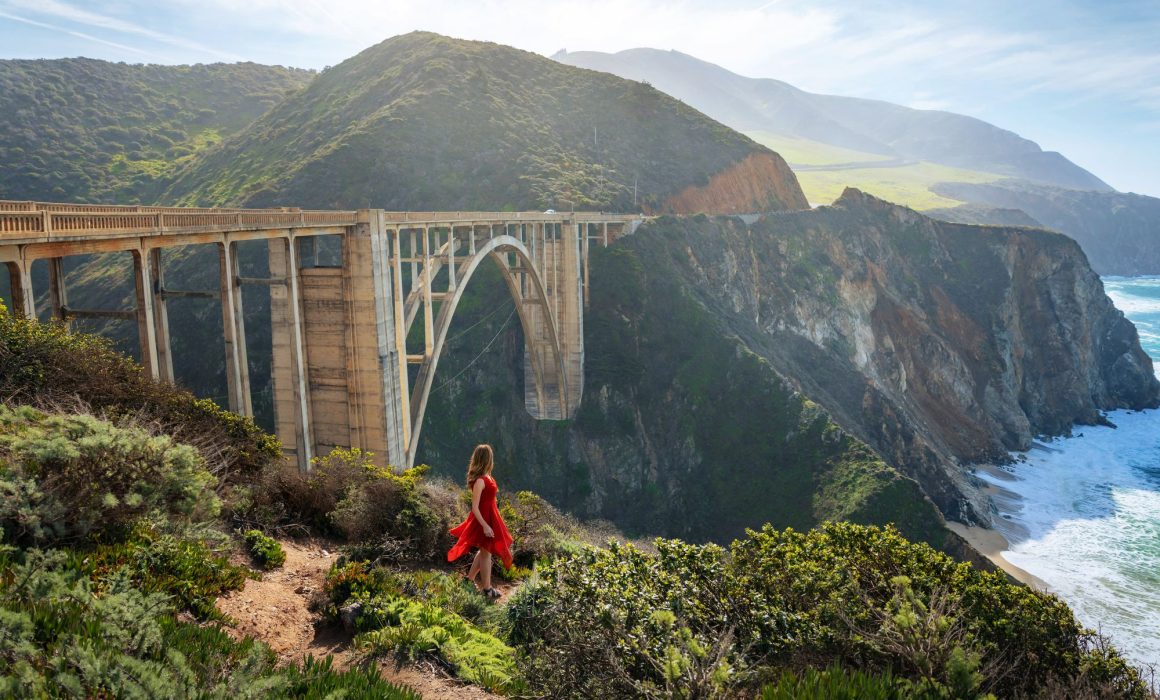 Bixby Bridge along Big Sur in California, with Asya Olson standing by the cliff.