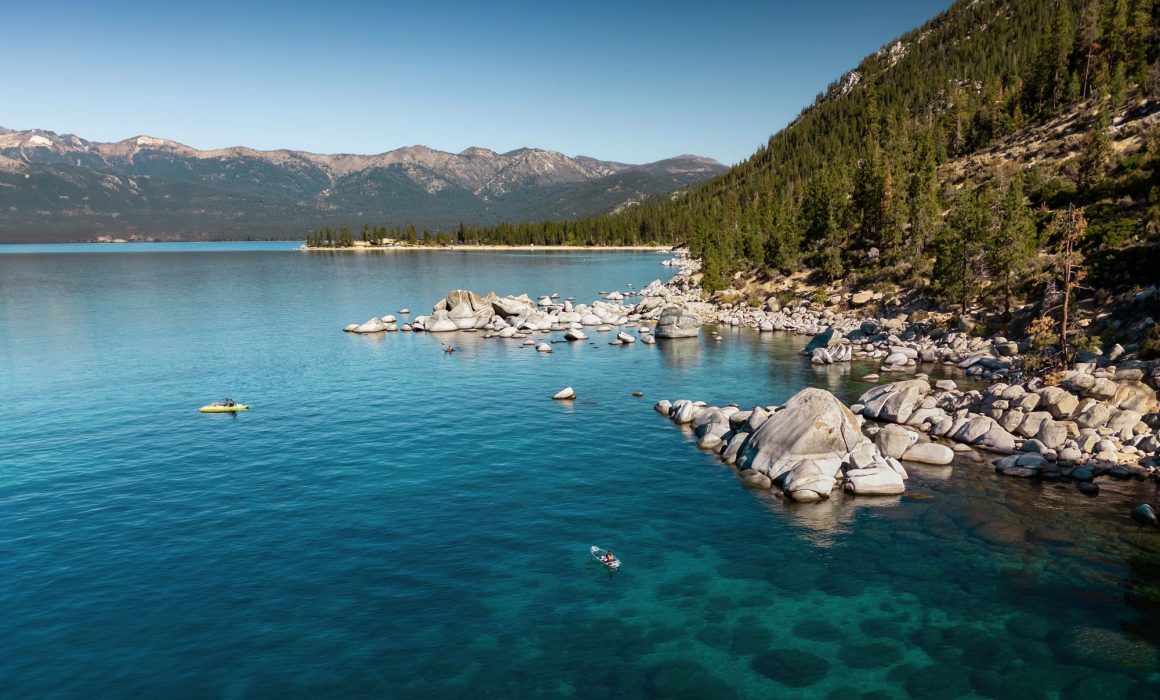 Lakeside of Lake Tahoe in California USA, with massive rocks and a gorgeous mountain side.