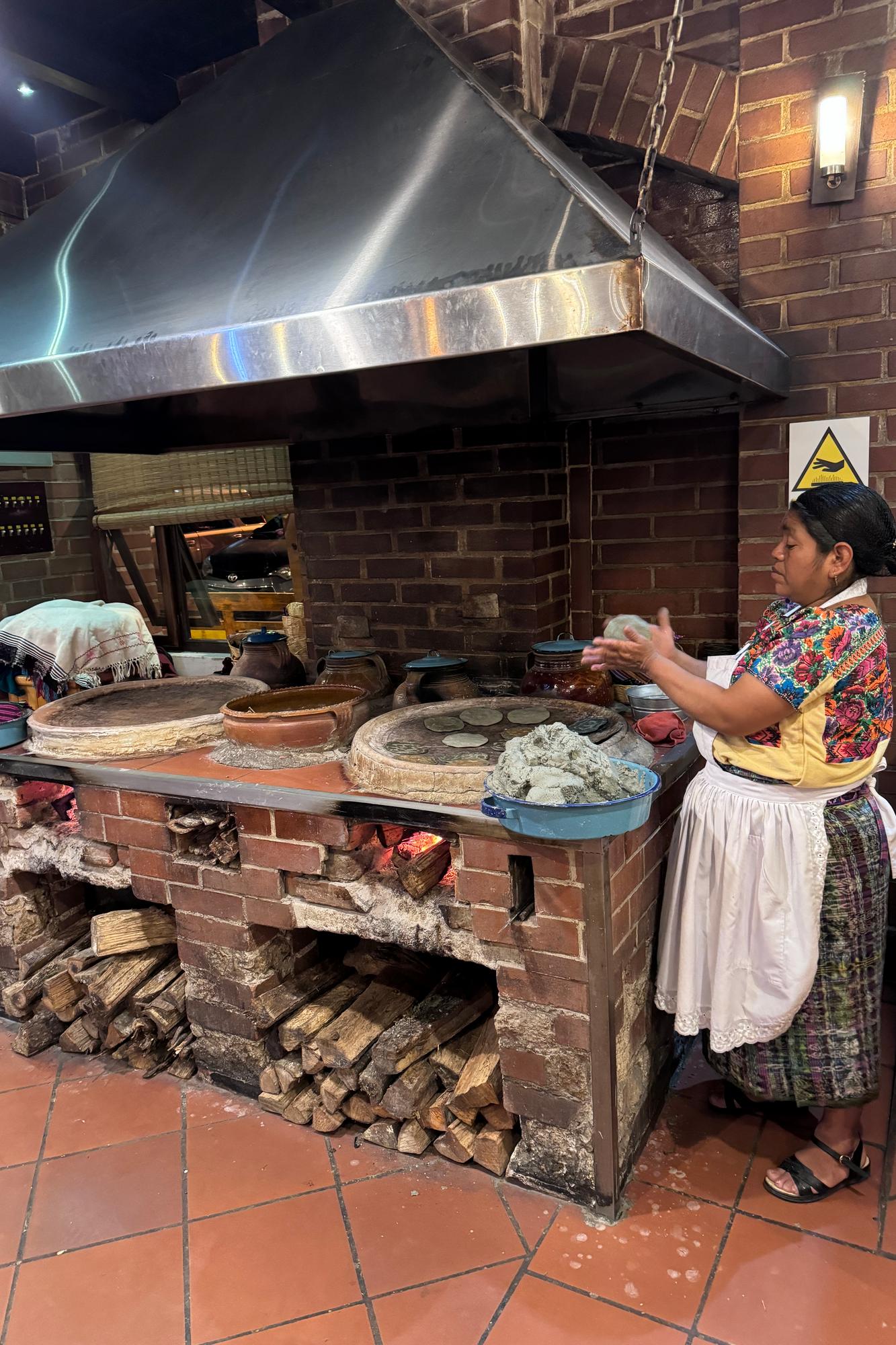 Santa Cruz Balanya A woman preparing a meal under a furnace cap in Santa Cruz La Laguna in Guatemala.