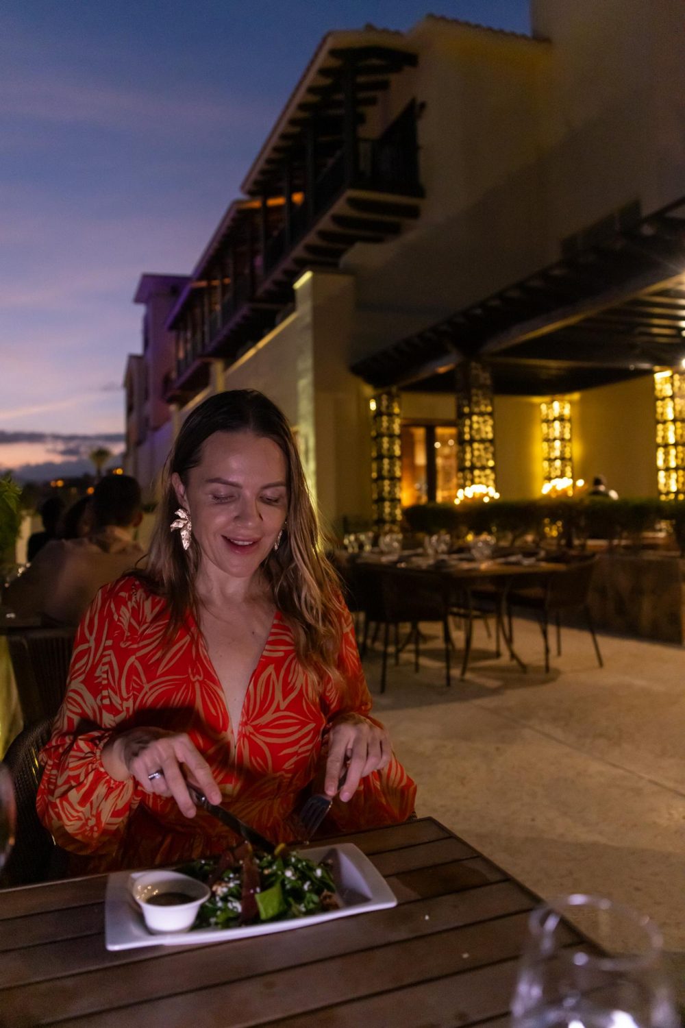 Woman having a meal at Portofino in Secrets Puerto, a resort in Los Cabos, during the evening.